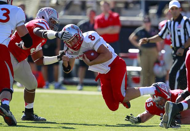 New Mexico quarterback Cole Gautsche is stopped by UNLV's Mark Garrick after being tripped up by Jordan Sparkman during UNLV's game against New Mexico at Sam Boyd Stadium Saturday, Nov. 3, 2012.