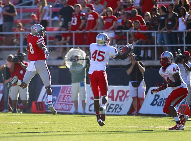 New Mexico's Tevin Newman intercepts a pass intended for UNLV's Caleb Herring, left, during UNLV's game against New Mexico at Sam Boyd Stadium Saturday, Nov. 3, 2012.