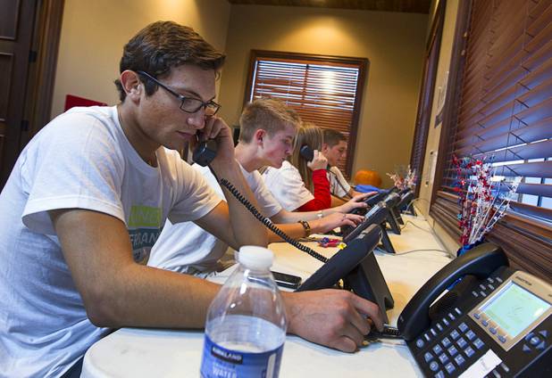 Dorian Achaval, left, 17, a volunteer for the Mitt Romney for President campaign, makes phone calls in a Henderson field office Monday, Nov. 5, 2012.