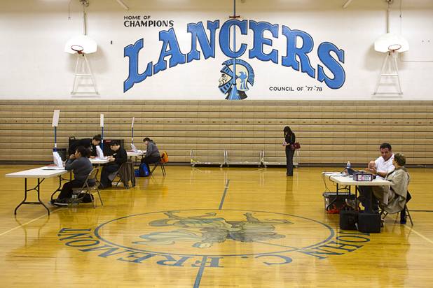 Election workers wait for voters during a lull on election day at the Fremont Middle School gym Tuesday, November 6, 2012.
