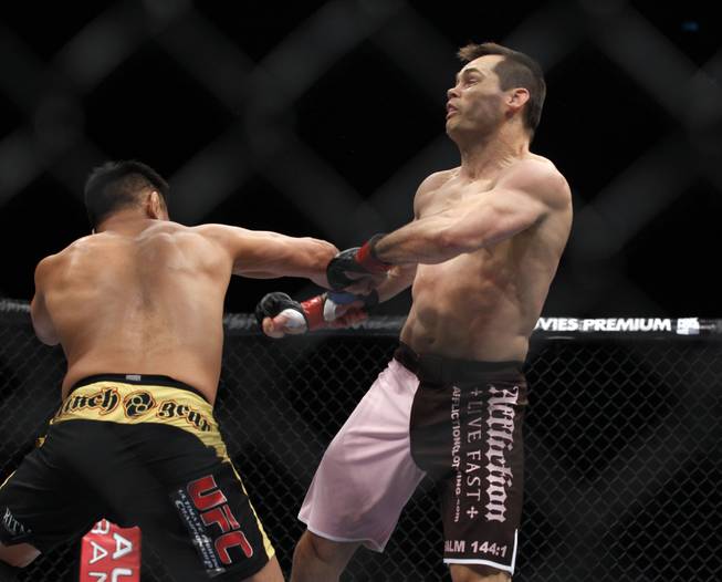 Cung Le, left, hits Rich Franklin during their middleweight Ultimate Fighting Championship match at the Venetian Macao in Macau on Saturday, Nov. 10, 2012. Le won by a knockout in the first round. 