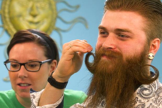 Ryan Hoppe of Ann Arbor, Mich. gets help from his wife Crystal as he prepares to compete in the third annual 2012 Beard Team USA National Beard and Moustache Championships at the Clark County Government Center amphitheater in downtown Las Vegas Sunday, November 11, 2012.