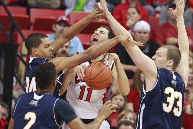 UNLV forward Carlos Lopez is trapped by Northern Arizona's, from left, Jordyn Martin, Michael Dunn and Max Jacobson during the Rebels season opener Monday, Nov. 12, 2012 at the Thomas & Mack. UNLV won 92-54.