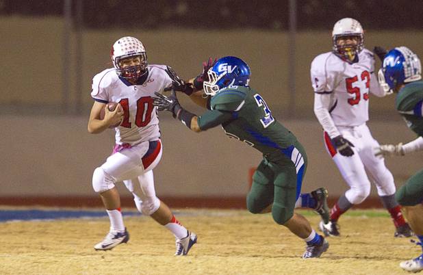 Coronado quarterback Kevin Lucero is pressured by Green Valley's Shai Gomez-Simmons during the Sunrise regional semifinal at Green Valley High School in Henderson Friday, November 16 , 2012.