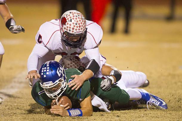 Green Valley quarterback Christian Lopez is sacked by Coronado defenders during the Sunrise regional semifinal at Green Valley High School in Henderson Friday, November 16 , 2012.