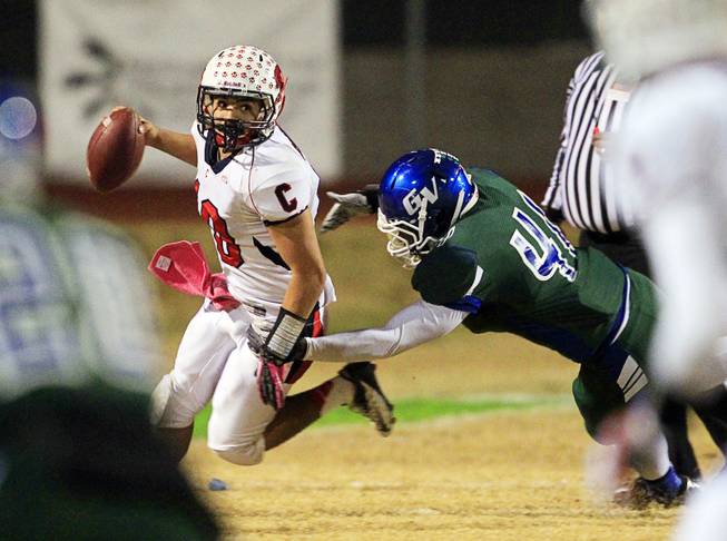 Coronado quarterback Kevin Lucero scrambles under pressure  by Green Valley's Rashawd Montgonery during the Sunrise regional semifinal at Green Valley High School in Henderson Friday, November 16 , 2012.