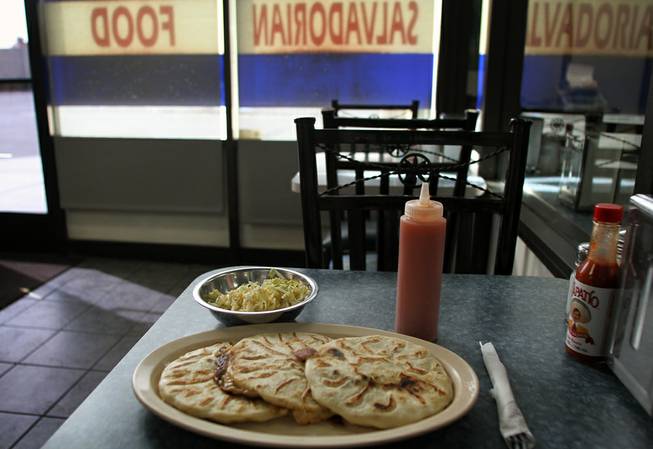 Three different versions of the eponymous dish at Las Pupusas sit ready to be consumed. The corn dough patties are filled with all sorts fo combination of meat, cheese and vegetables. The three pictures are filled with pork and cheese, chicken and cheese and cheese and herbs.