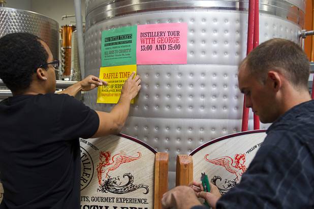 Workers posts signs as they get ready for the Historic First Edition Day at the Las Vegas Distillery in Henderson Saturday, November 17, 2012. The event marks the first bottling of several new spirits and the grand opening of the Booze Brothers Beverage distribution company and the Half Full Artisan Shop at the Distillery, a retail store. The spirits include Nevada vodka, whiskey, gin, rum and moonshine.