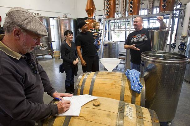 Bret Stanley, right, holds up a bucket of single malt whiskey as he invite guests to help fill a barrel during the Historic First Edition Day at the Las Vegas Distillery in Henderson Saturday, November 17, 2012. The whiskey will be aged for three years, he said.The event marks the first bottling of several new spirits and the grand opening of the Booze Brothers Beverage distribution company and the Half Full Artisan Shop at the Distillery, a retail store. The spirits include Nevada vodka, whiskey, gin, rum and moonshine.