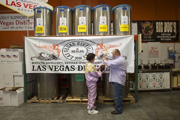 Beverly Brown gets help from Las Vegas Distillery founder George Racz as she fills the first bottle of Nevada whiskey during the Historic First Edition Day at the Las Vegas Distillery in Henderson Saturday, November 17, 2012. The event marks the first bottling of several new spirits and the grand opening of the Booze Brothers Beverage distribution company and the Half Full Artisan Shop at the Distillery, a retail store. The spirits include Nevada vodka, whiskey, gin, rum and moonshine.