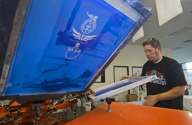 Shawn Beagley customizes T-shirts at the Half Full Artisan Shop at the Distillery during the Historic First Edition Day at the Las Vegas Distillery in Henderson Saturday, November 17, 2012. The event marks the first bottling of several new spirits and the grand opening of the Booze Brothers Beverages distribution company and the Half Full retail store. The spirits include Nevada vodka, whiskey, gin, rum and moonshine.