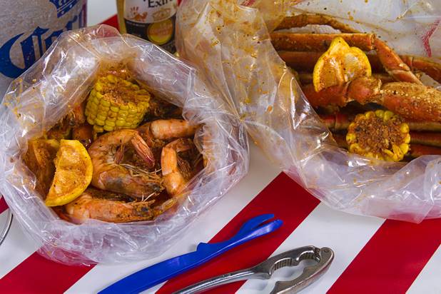 Bags of shrimp and snow crab at California Crab, a restaurant at 9560 S. Eastern Ave. Sunday, November 18, 2012. Shrimp, left, served with corn, lemon and potatoes, is $9.99 per pound. Snow crabs legs, right, are market priced. Bananas in Pajamas ($6.99) is a bowl of Magnolia ube, a Filipino purple yam ice cream, surrounded by small sticks of hot fried bananas.