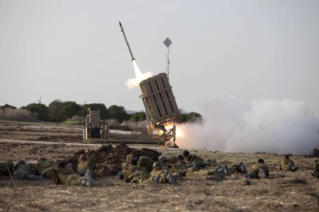 Israeli soldiers lie on the ground as an Iron Dome missile is launched near the city of Ashdod, Israel, Monday Nov 19, 2012.