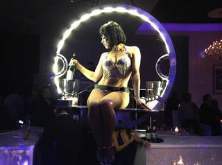 Champagne is served from a model who descends from the ceiling at the grand opening of Bagatelle nightclub and restaurant on Nov. 16, 2012, at the Tropicana.