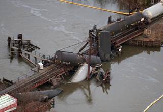 Derailed freight train cars lay in water in Paulsboro, N.J., Friday, Nov. 30, 2012. People in three southern New Jersey towns were told Friday to stay inside after the freight train derailed and several tanker cars carrying hazardous materials toppled from a bridge and into a creek.