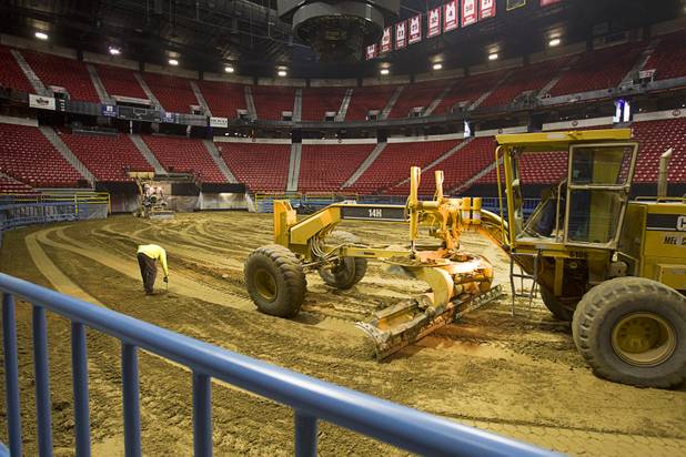Remberto Gonzalez checks the depth of soil as workers prepare the Thomas & Mack Center for the National Finals Rodeo Sunday, Dec. 2, 2012. The area floor is covered with 9-12 inches of dirt. This year's NFR begins Thursday, Dec. 6 and runs through Saturday Dec. 15.