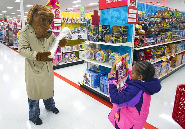 Nevaeh McCaskel, 6, compares presents with McGruff the Crime Dog during an annual Shop With A Cop event at the Target store at 2189 W. Craig Rd. in North Las Vegas, Wednesday, December 5, 2012. McGruff got a bone.