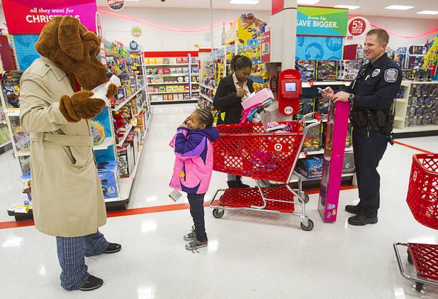 Nevaeh McCaskel, 6, compares presents with McGruff the Crime Dog during an annual Shop With A Cop event at the Target store at 2189 W. Craig Rd. in North Las Vegas, Wednesday, December 5, 2012. McGruff got a bone. Shopping with Nevaeh are her mother Mary Portis and North Las Vegas Police officer Lucas Nelson.