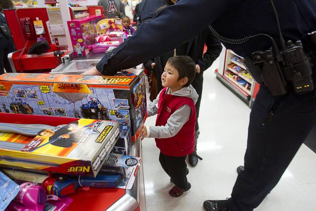 Romeo Salango, 4, looks over his presents at the checkout line during an annual Shop With A Cop event at the Target store at 2189 W. Craig Rd. in North Las Vegas, Wednesday, December 5, 2012.