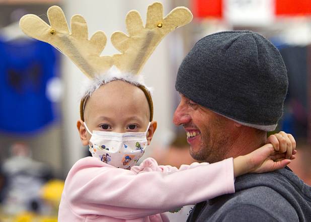 Cancer patient Junaisy Vargas, 5, is held by her father Antonio Vargas during an annual Shop With A Cop event at the Target store at 2189 W. Craig Rd. in North Las Vegas, Wednesday, December 5, 2012.