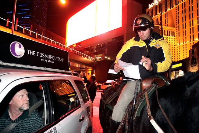 Officer Tim Ruiz of the Las Vegas Metropolitan Police Mounted Unit talks to a taxi driver they pulled over on Harmon Avenue just east of the Las Vegas Strip on Friday, December 7, 2012.