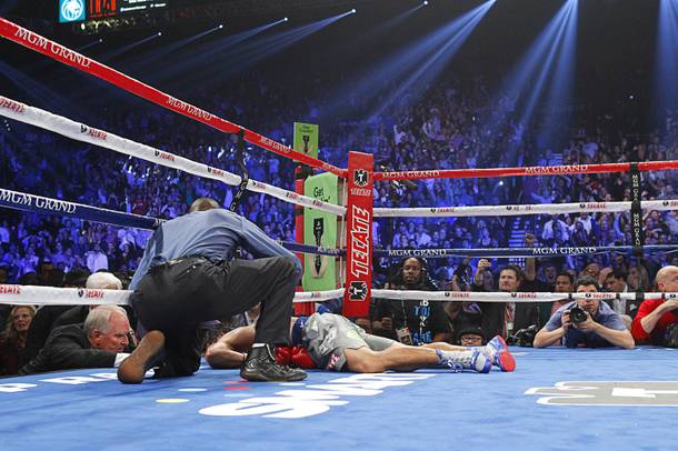 Referee Kenny Bayless looks over Manny Pacquiao of the Philippines after he was knocked out by Juan Manuel Marquez of Mexico during their welterweight fight at the MGM Grand Garden Arena in Las Vegas, Nevada December 8, 2012.