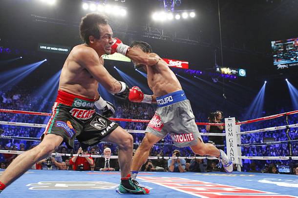 Juan Manuel Marquez (L) of Mexico takes a hit from Manny Pacquiao of the Philippines during their welterweight fight at the MGM Grand Garden Arena in Las Vegas, Nevada December 8, 2012.