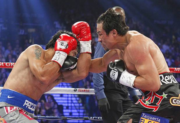 Manny Pacquiao (L) of the Philippines fights Juan Manuel Marquez of Mexico during their welterweight fight at the MGM Grand Garden Arena in Las Vegas, Nevada December 8, 2012.