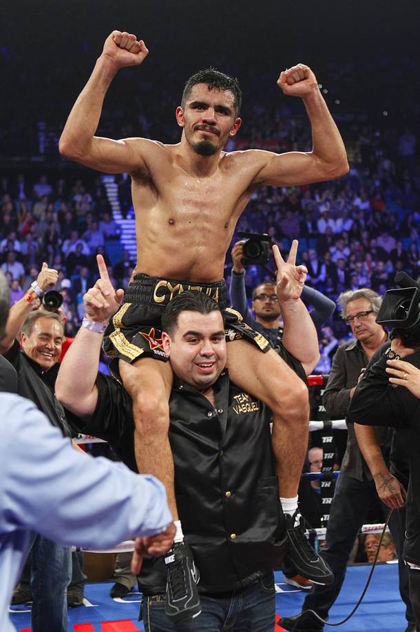 IBF lightweight boxer Miguel Angel Vazquez (top) of Mexico celebrates his victory over Mercito Gesta of the Philippines following their title fight at the MGM Grand Garden Arena in Las Vegas, Nevada December 8, 2012.