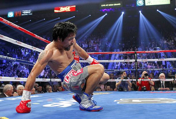 Manny Pacquiao of the Philippines rises from the canvas after being knocked down by Juan Manuel Marquez of Mexico in the third round of their welterweight fight at the MGM Grand Garden Arena in Las Vegas, Nevada December 8, 2012.