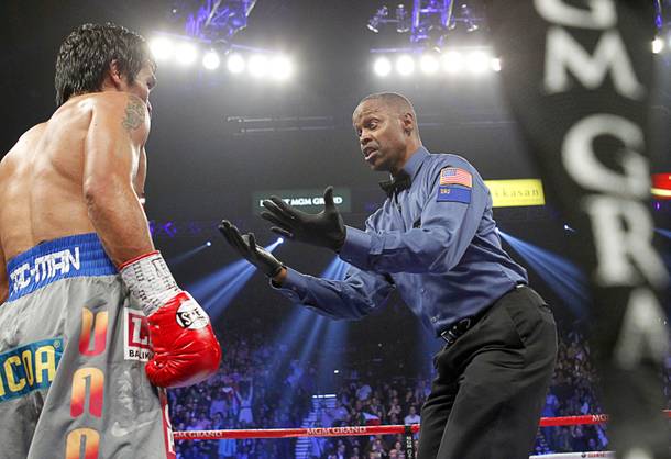 Referee Kenny Bayless gestures to Manny Pacquiao of the Philippines after Pacquiao was knocked down by Juan Manuel Marquez of Mexico in the third round of their welterweight fight at the MGM Grand Garden Arena in Las Vegas, Nevada December 8, 2012.