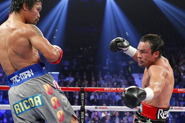 Manny Pacquiao of the Philippines watches as Juan Manuel Marquez of Mexico is knocked down in the fifth round of their welterweight fight at the MGM Grand Garden Arena in Las Vegas, Nevada December 8, 2012.
