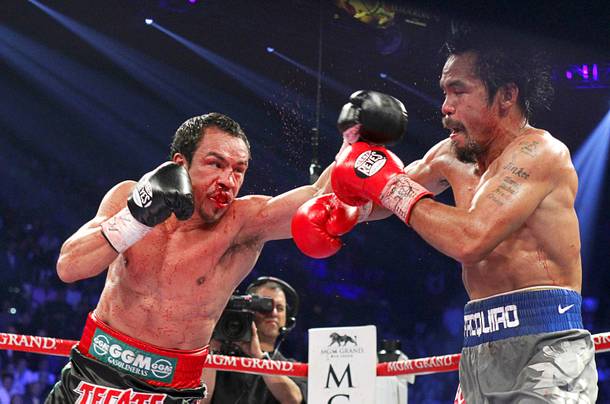 Juan Manuel Marquez (L) of Mexico punches at Manny Pacquiao of the Philippines during their welterweight fight at the MGM Grand Garden Arena in Las Vegas, Nevada December 8, 2012.