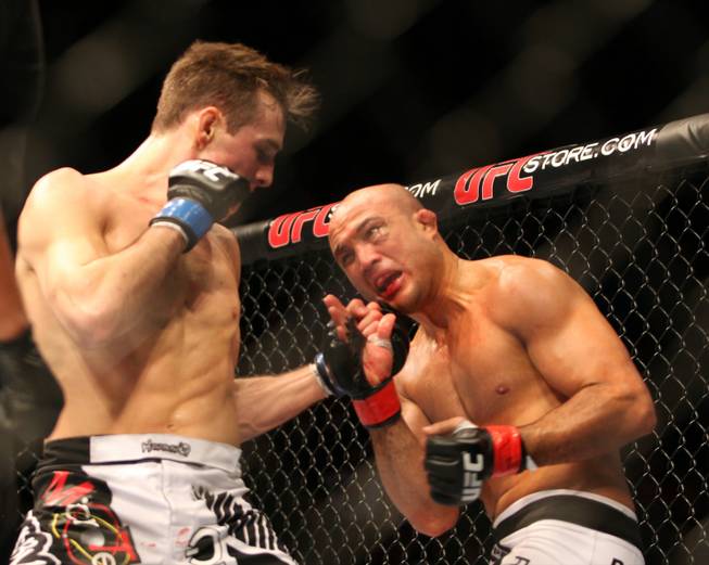 BJ Penn, right, takes a punch from Rory MacDonald during their mixed martial arts bout at a UFC on FOX 5 event in Seattle on Saturday, Dec. 8, 2012. MacDonald won via a unanimous decision.