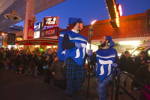 Levi Ehrentrei, left and Levi Harlig, dressed as dreidels, hold a torch during a Hanukah menorah lightning ceremony at the Fremont Street Experience in downtown Las Vegas Sunday, Dec. 9, 2012.  Chabad of Southern Nevada sponsored the event. The Jewish holiday of Hanukah started Saturday evening and runs though Dec. 16.