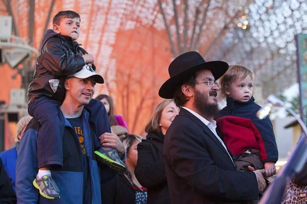Ilan Klein, 5, watches performances from his father's shoulders during a Hanukah menorah lightning ceremony at the Fremont Street Experience in downtown Las Vegas Sunday, Dec. 9, 2012.  At right, Tzui Brunchtain holds his two-year-old son Yaakov. Chabad of Southern Nevada sponsored the event. The Jewish holiday of Hanukah started Saturday evening and runs though Dec. 16.