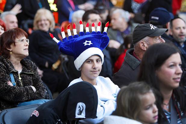 Seth Goldklang, center, 13, wears a menorah hat during a Hanukah menorah lightning ceremony at the Fremont Street Experience in downtown Las Vegas Sunday, Dec. 9, 2012.  Chabad of Southern Nevada sponsored the event. The Jewish holiday of Hanukah started Saturday evening and runs though Dec. 16.