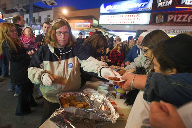 Shawn Goldblatt hands out potato latkes during a Hanukah menorah lightning ceremony at the Fremont Street Experience in downtown Las Vegas Sunday, Dec. 9, 2012.  Chabad of Southern Nevada sponsored the event. The Jewish holiday of Hanukah started Saturday evening and runs though Dec. 16.