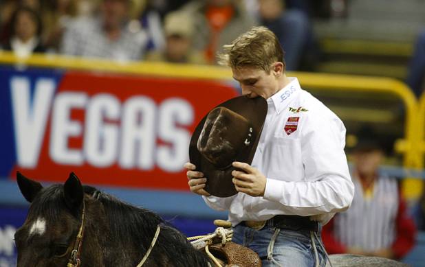 Tie-down roper Tuf Cooper appears to bite his hat as he waits for his score during the fourth go-round of the Wrangler National Finals Rodeo at the Thomas & Mack Center Sunday, Dec. 9, 2012. Cooper tied his calf in just 7.8 seconds, the best time of the night. The NFR continues through Saturday.