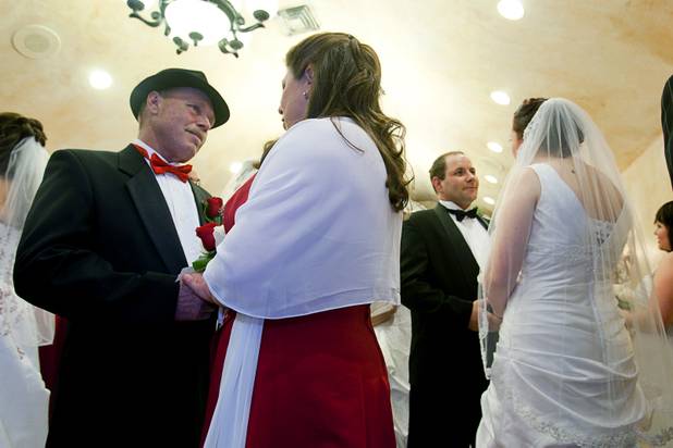 Michael Thurman, left, and Susanna Repasy, and Christopher Shultz and Jessica Cook get married in a group wedding at the Chapel of the Flowers on Las Vegas Boulevard South Wednesday, Dec. 12, 2012. Twelve couples got married at 12:12 pm at the chapel as part of a KOMP 92.3 radio station promotion. Las Vegas wedding chapels were busy all day as many couples wanted to get married on the date of 12-12-12.