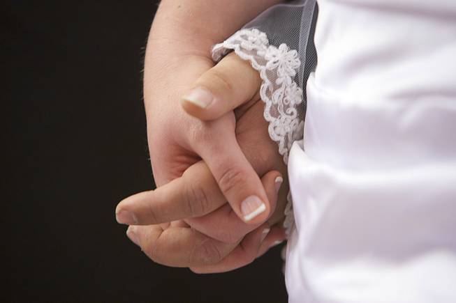 A couple holds hands during a group wedding at the Chapel of the Flowers on Las Vegas Boulevard South Wednesday, Dec. 12, 2012. Twelve couples got married at 12:12 pm at the chapel as part of a KOMP 92.3 radio station promotion. Las Vegas wedding chapels were busy all day as many couples wanted to get married on the date of 12-12-12.