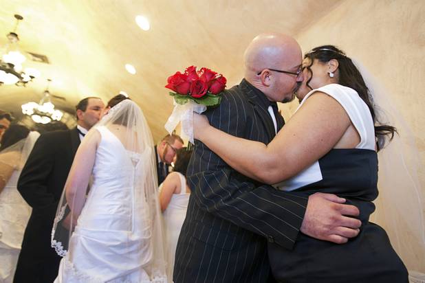 Scott Palmer and Maria St.Clair kiss after getting married in a group wedding at the Chapel of the Flowers on Las Vegas Boulevard South Wednesday, Dec. 12, 2012. Twelve couples got married at 12:12 pm at the chapel as part of a KOMP 92.3 radio station promotion. Las Vegas wedding chapels were busy all day as many couples wanted to get married on the date of 12-12-12.