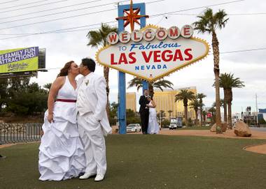 Jacqueline Plysier and Dominique Vilay of Paris, France, kiss as they pose for photos after getting married in Las Vegas on Wednesday, Dec. 12, 2012. Eric Howell and Paola Teran of Stanton, Calif., are in the background. Las Vegas wedding chapels were busy all day as many couples wanted to get married on the unique date of&nbsp;12-12-12.