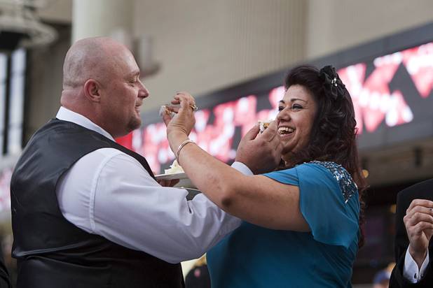 James Nottingham and his bride Lucy Garcia celebrate with cake at the Fremont Street Experience Wednesday, Dec. 12, 2012. Twelve couples got married at 12:12 pm at the Chapel of the Flowers as part of a KOMP 92.3 radio station promotion. The D Las Vegas put the couples up in newly upgraded rooms, hosted a reception and gave them tickets to "Marriage Can Be Murder," a comedy, murder-mystery dinner show.