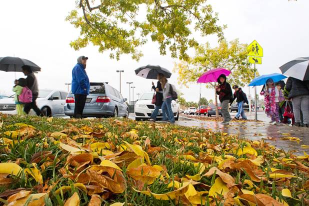 Students carry umbrellas as they leave Bartlett Elementary School during light rain in Henderson Thursday, Dec. 13, 2012. The storm system is expected to bring up to a half-inch of rain this afternoon and evening across the Las Vegas Valley. 