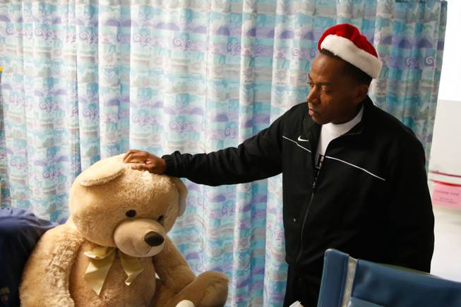 Clark County Commissioner Lawrence Weekly hands out stuffed animals to children at UMC's pediatric unit, Thursday, Dec. 13, 2012.