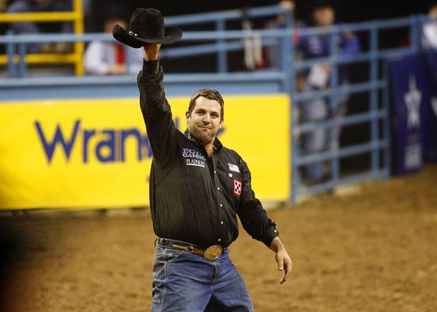 Steer wrestler Luke Branquinho of Los Alamos, Calif. lifts his hat after competing in the final night of the Wrangler National Finals Rodeo Saturday, Dec. 15, 2012. Branquinho took the steer wrestling championship.
