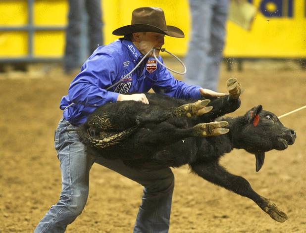 Tie-down roper Tuf Cooper of Decatur, Texas flips his calf during the final night of the Wrangler National Finals Rodeo Saturday, Dec. 15, 2012. Cooper won the championship in tie-down roping.