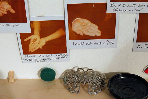 Items are displayed on an exchange wall at the Ellen Harvey Exhibit at the P3 Studio in the Cosmopolitan Monday, Dec. 17, 2012. "Exchange Your Luck" allows guests to swap ineffective lucky charms for new ones.  Two adjacent shelves in P3Studio will hold two sets of 77 different small bronze lucky charms by Ellen Harvey.  Each charm will be an edition of only two. One set of charms will stay in P3Studio for the duration of the residency, while the other set is available for guests to take provided they leave their own lucky charm in exchange. The object for which the charm is swapped will be photographed and its Polaroid installed on the wall.