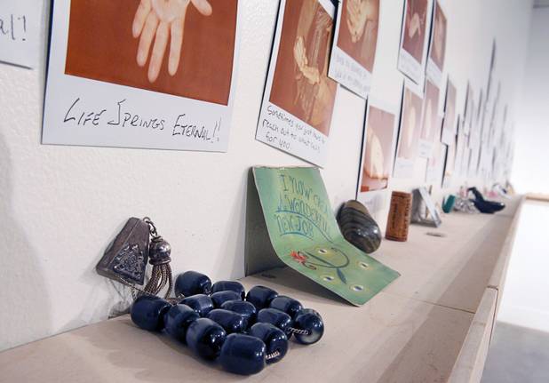 Items are displayed on an exchange wall at the Ellen Harvey Exhibit at the P3 Studio in the Cosmopolitan Monday, Dec. 17, 2012. "Exchange Your Luck" allows guests to swap ineffective lucky charms for new ones.  Two adjacent shelves in P3Studio will hold two sets of 77 different small bronze lucky charms by Ellen Harvey.  Each charm will be an edition of only two. One set of charms will stay in P3Studio for the duration of the residency, while the other set is available for guests to take provided they leave their own lucky charm in exchange. The object for which the charm is swapped will be photographed and its Polaroid installed on the wall.